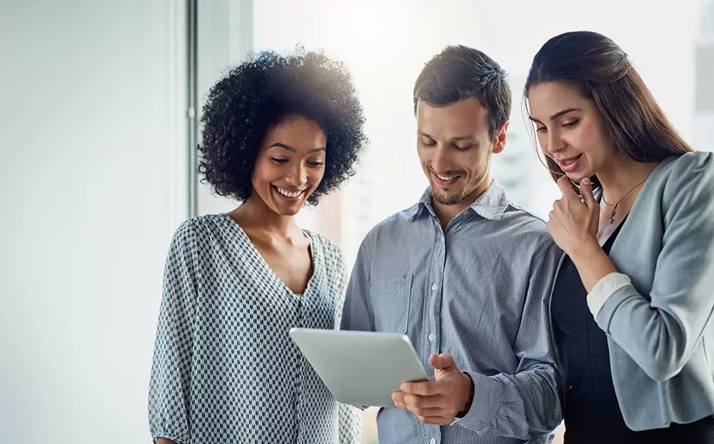 Shot of a group of young businesspeople using a digital tablet together in a modern office